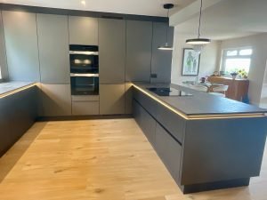 Modern dark kitchen - Cooking area of kitchen with hob on peninsular